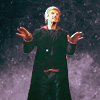 Twelve looking like he is summoning a demon in front of a window overlooking deep space.